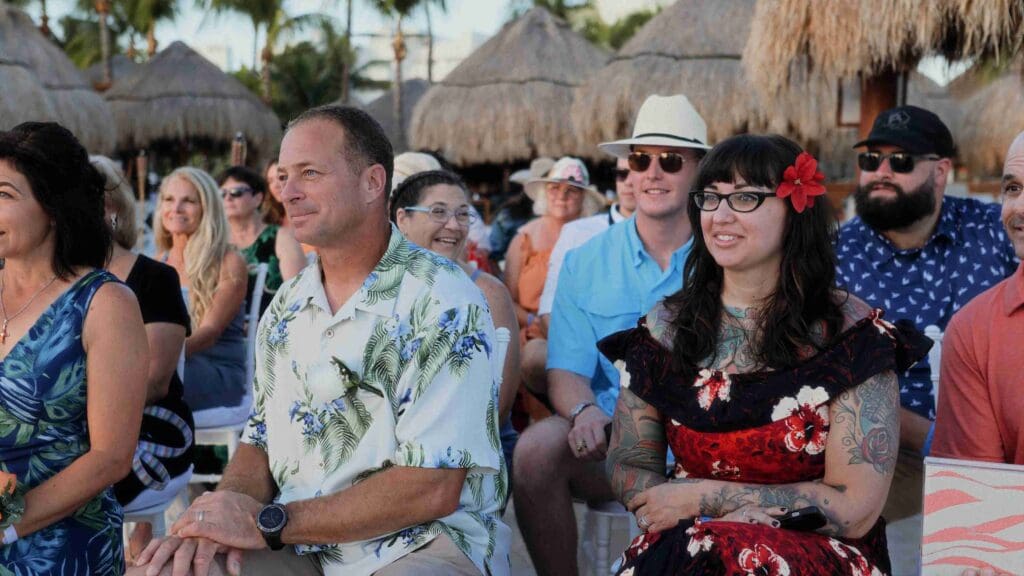 Guests smiling at a beach destination wedding ceremony